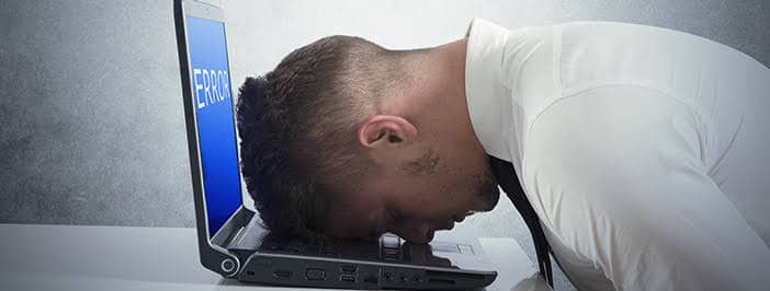 IT support man taking a nap on a broken laptop.