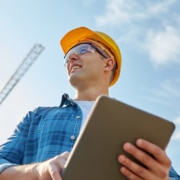 Construction Foreman In Yellow Hardhat Holding a Clipboard