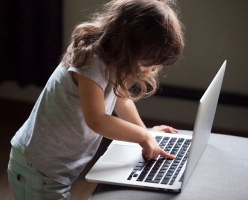 Child Pressing Buttons on a Laptop