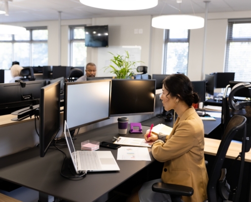 a few coworkers in an office working on their computers, using office 365 security