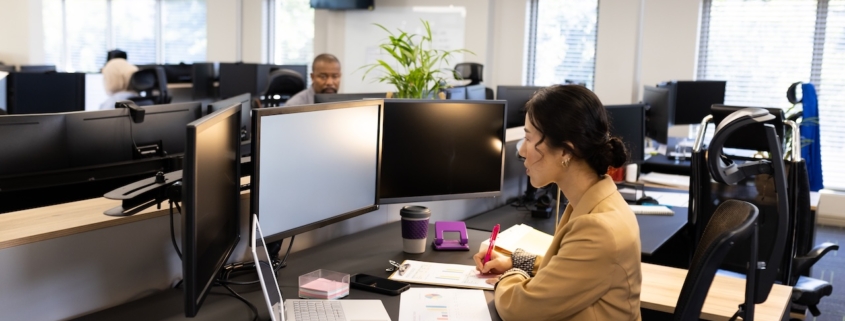 a few coworkers in an office working on their computers, using office 365 security