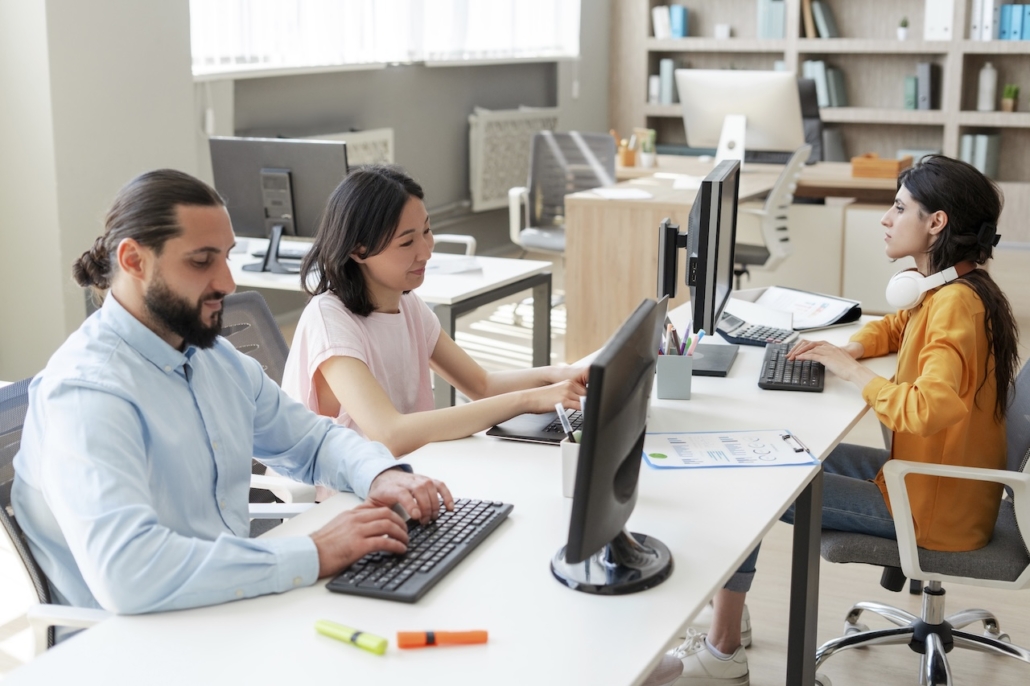 group of employees working on computer in office with managed cloud service provider support