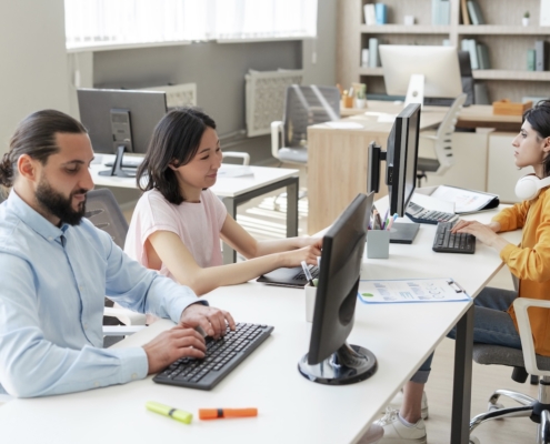 group of employees working on computer in office with managed cloud service provider support