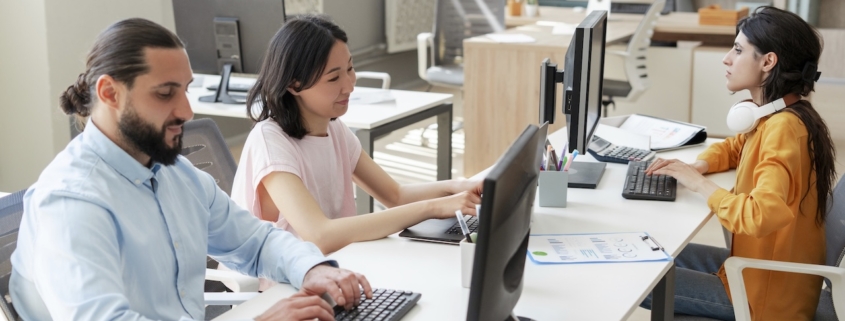 group of employees working on computer in office with managed cloud service provider support