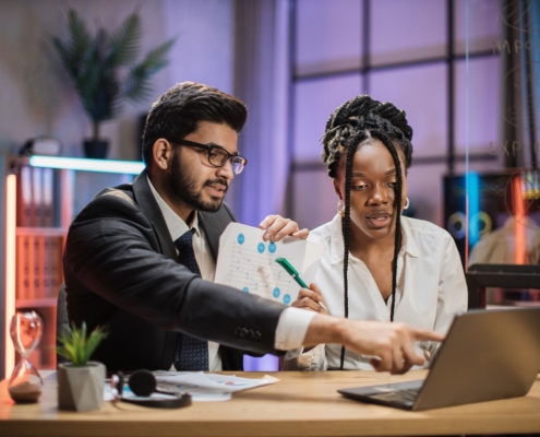 two coworkers in office working on computer with managed IT services