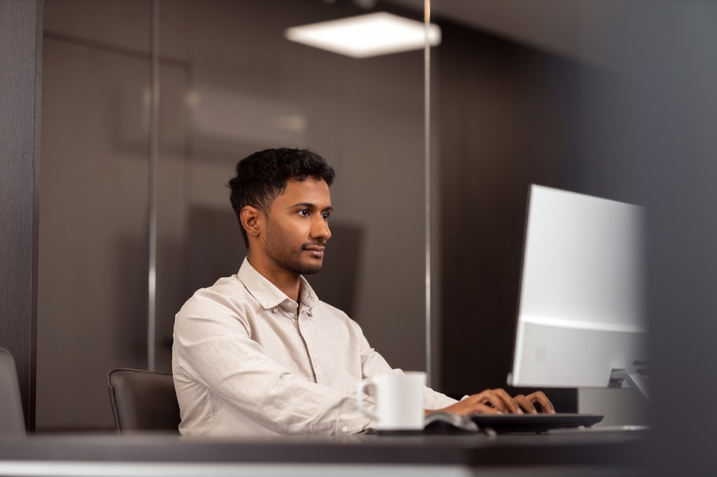 man working in office on computer using IT support and managed services