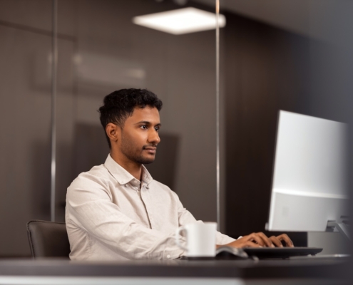 man working in office on computer using IT support and managed services