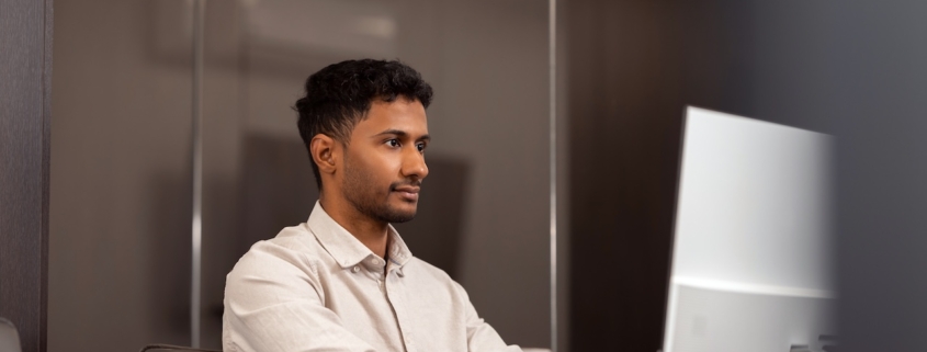 man working in office on computer using IT support and managed services