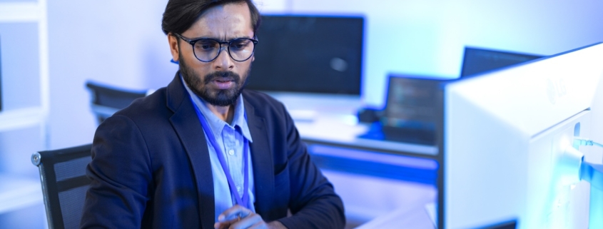 man working on computer in office with proper network security