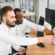 men working in office on computer looking at monitor
