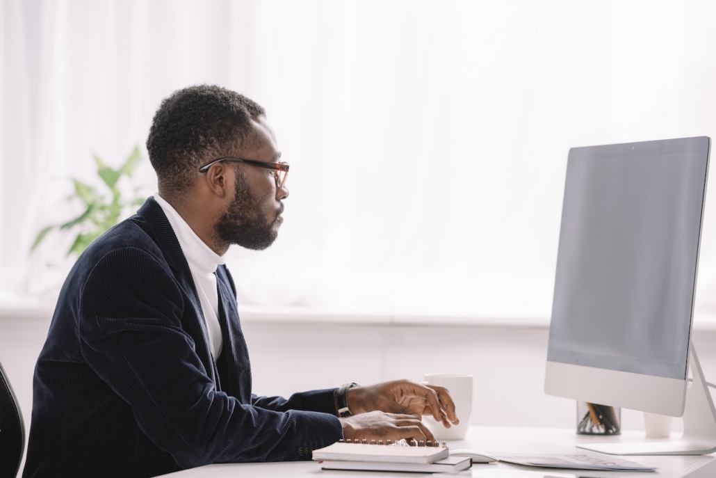 man working on computer in well-lit office