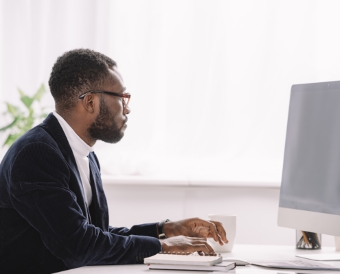 man working on computer in well-lit office