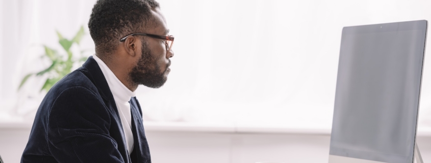 man working on computer in well-lit office