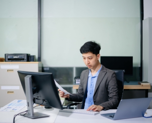 Professional businessman in suit working at office desk with laptop