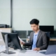 Professional businessman in suit working at office desk with laptop