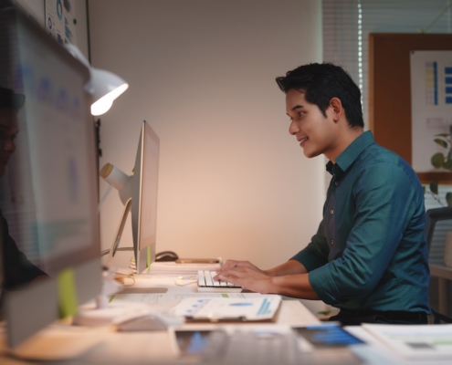 man working on computer in dimly lit office