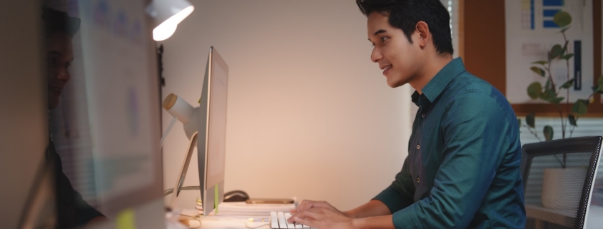 man working on computer in dimly lit office